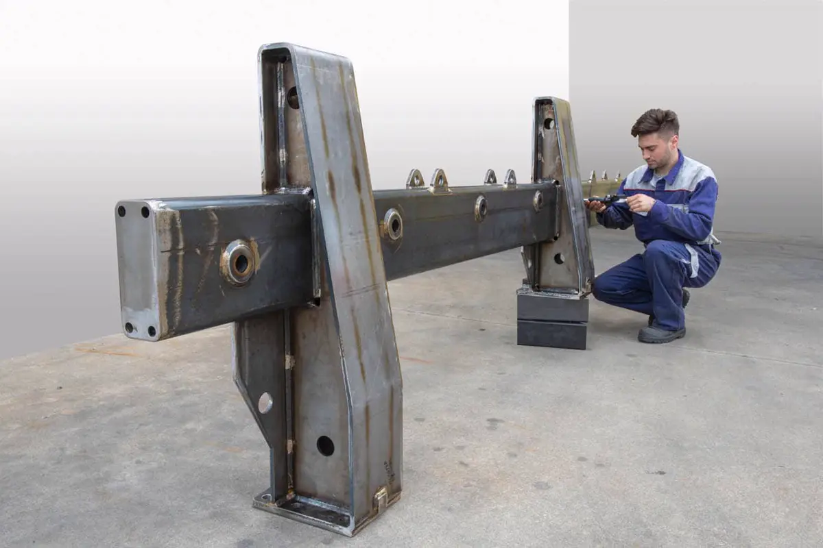 Un operatore Metaltech controlla un grande telaio saldato